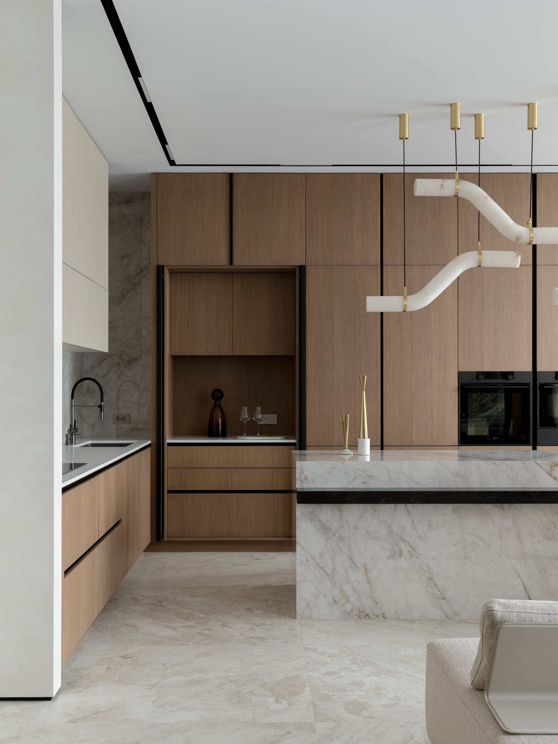 The working wall of the kitchen, where oak cabinetry meets a stone-clad splashback in a quieter register
