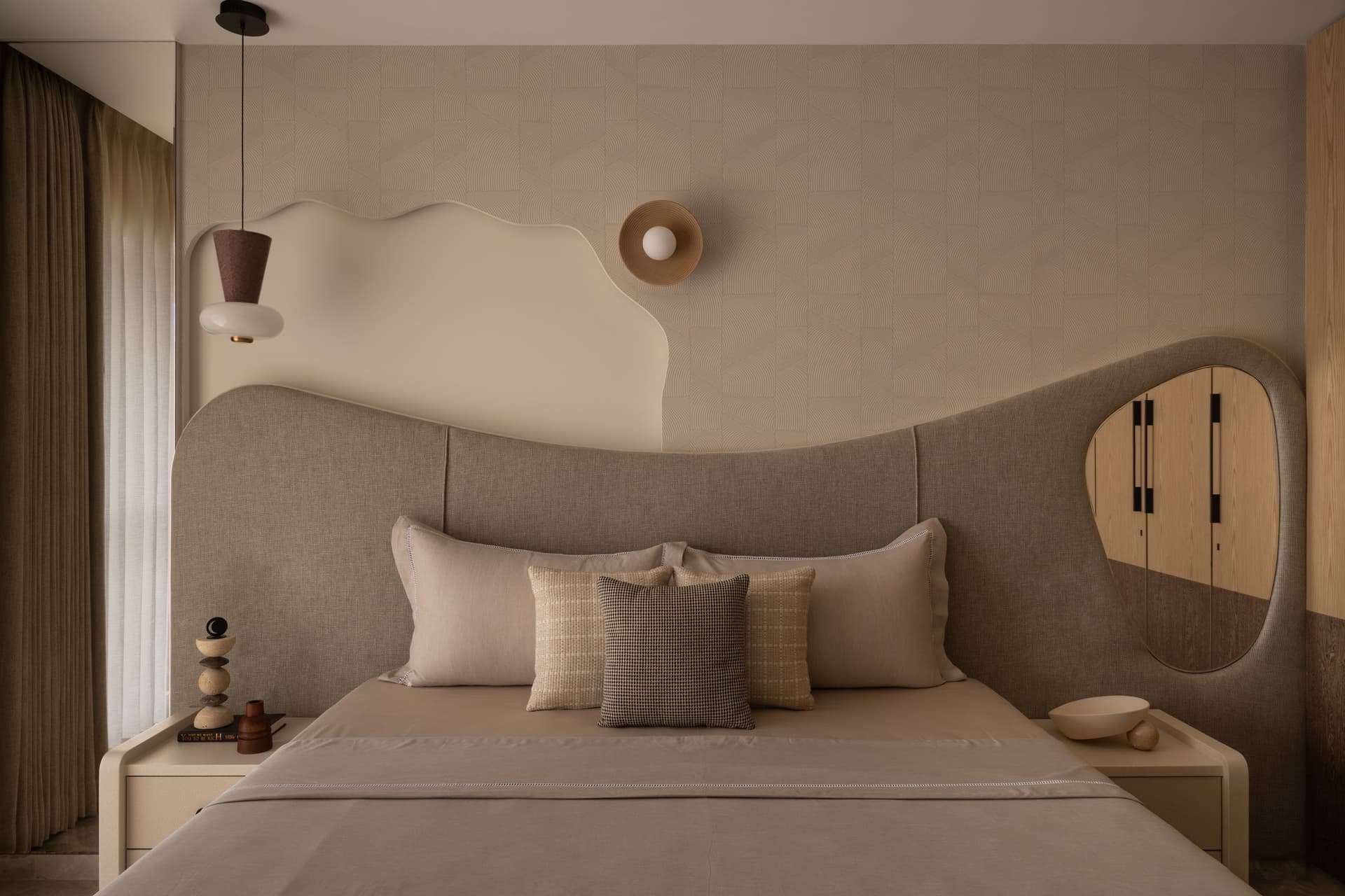 The master bedroom, where a curved upholstered headboard and sculpted white form soften the architectural plane