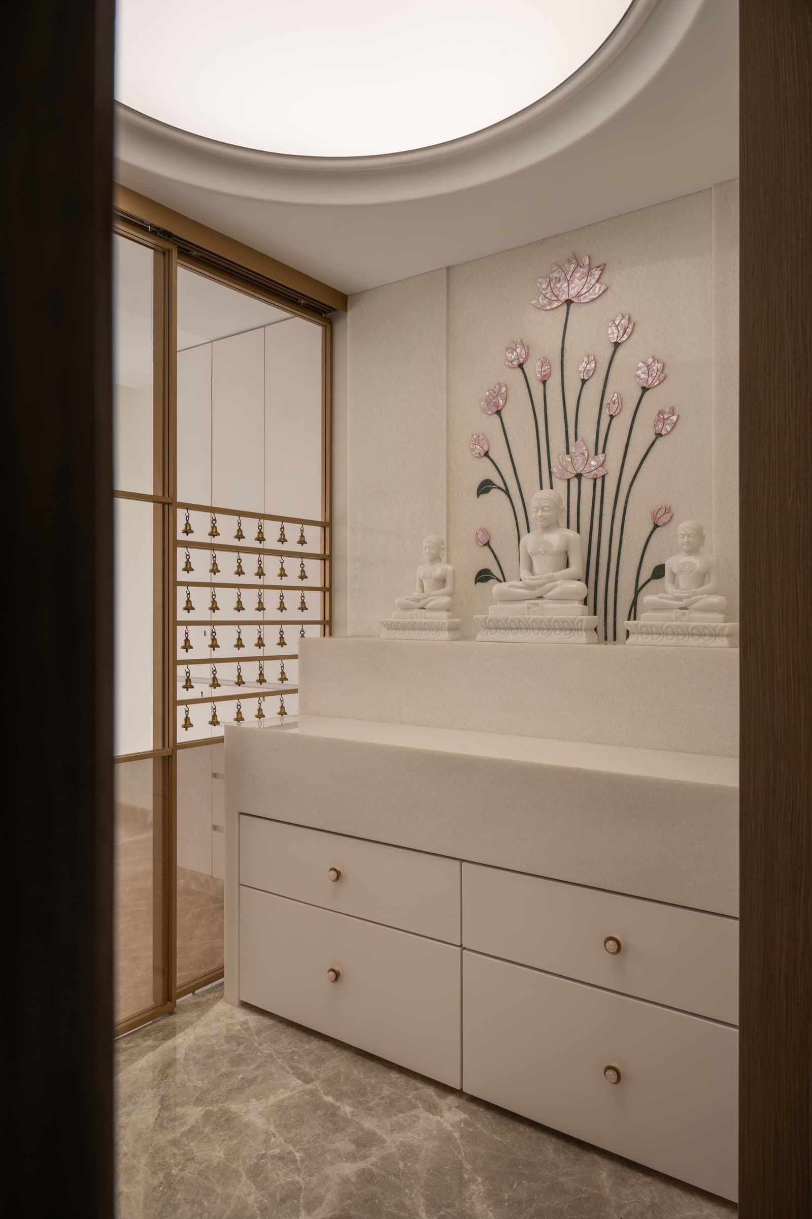 The prayer room, where a lotus mural in coloured inlay and a bell screen frame the family's daily ritual