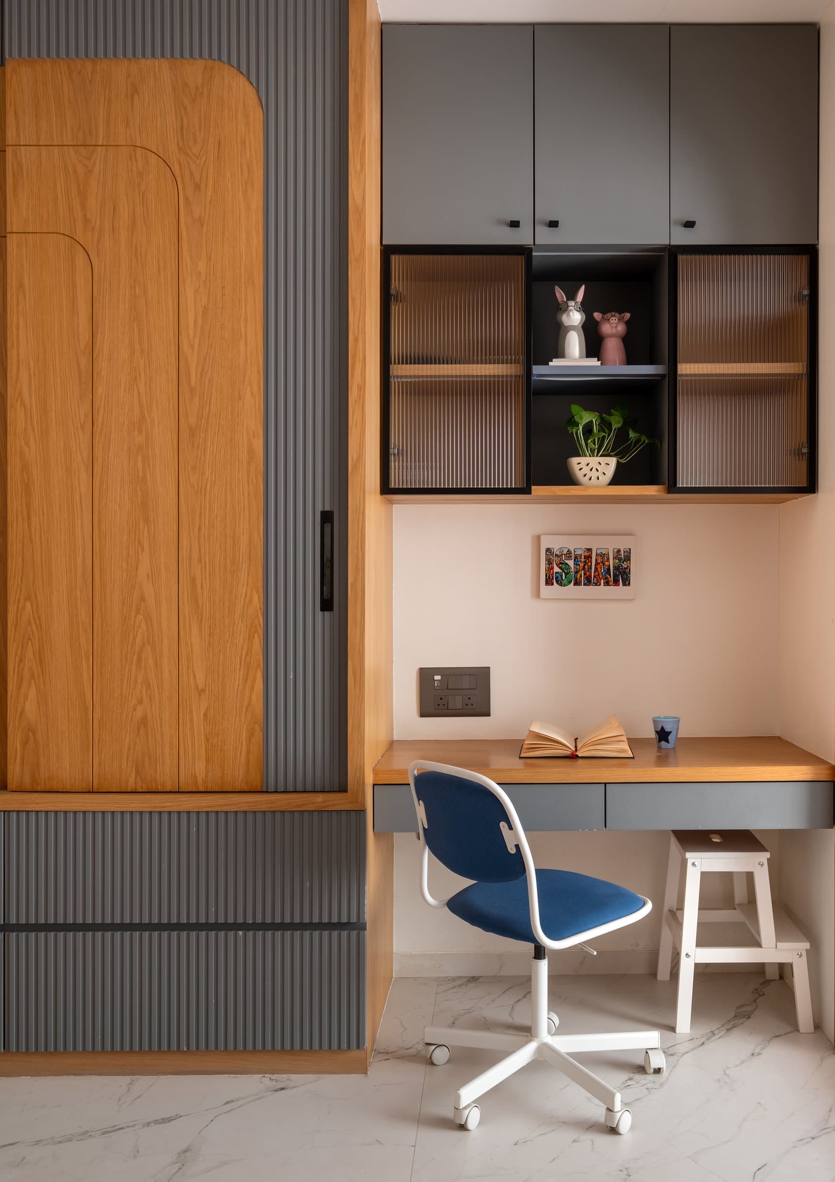 The desk wall in the children's room, where warm oak joinery meets grey fluted panels and reeded glass