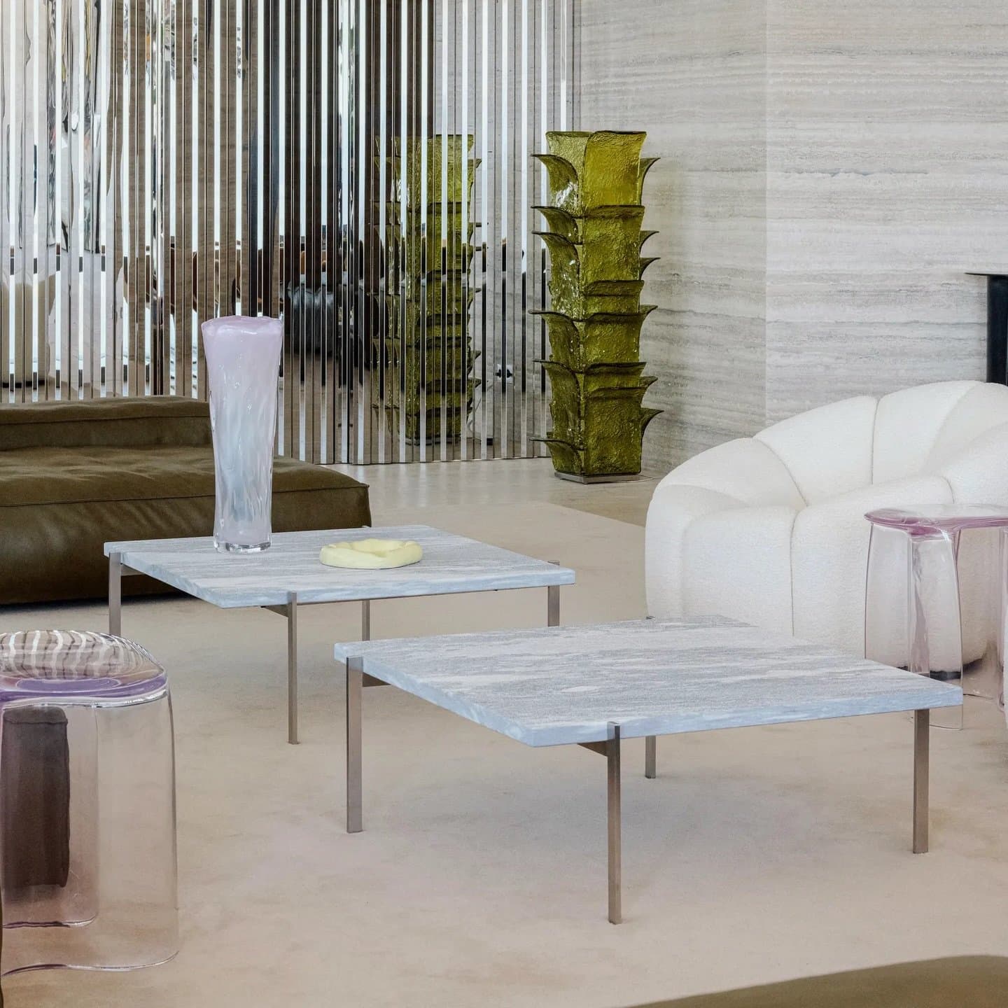 A vertical metal slat screen filters the light, layering privacy into an otherwise open plan.