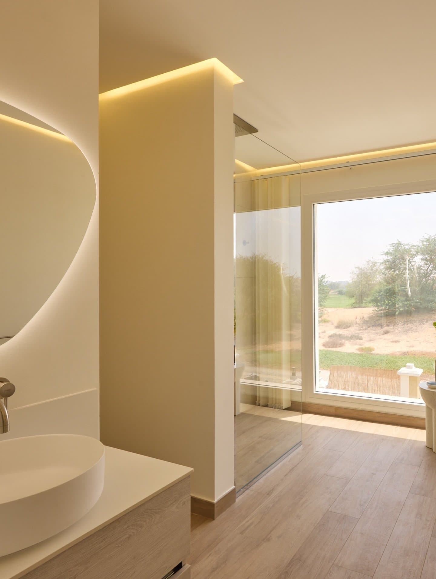 A sculptural partition wall organises the bathroom without severing its zones.