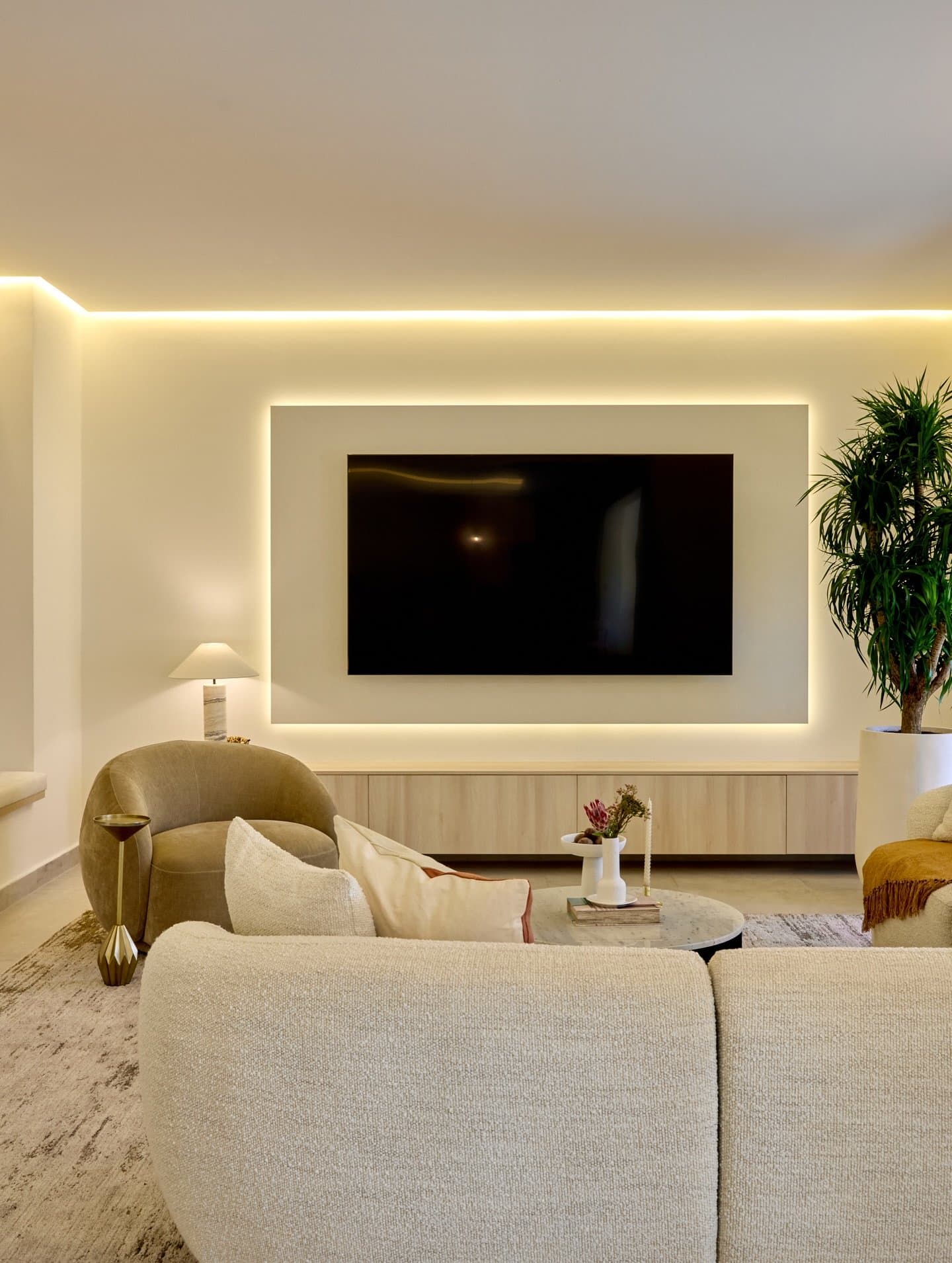 A backlit niche frames the television, becoming the room's quiet architectural event.