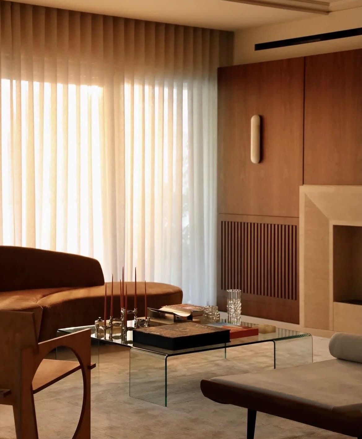 Sheer drapery and a curved velvet sofa establish the living room's amber-washed atmosphere.