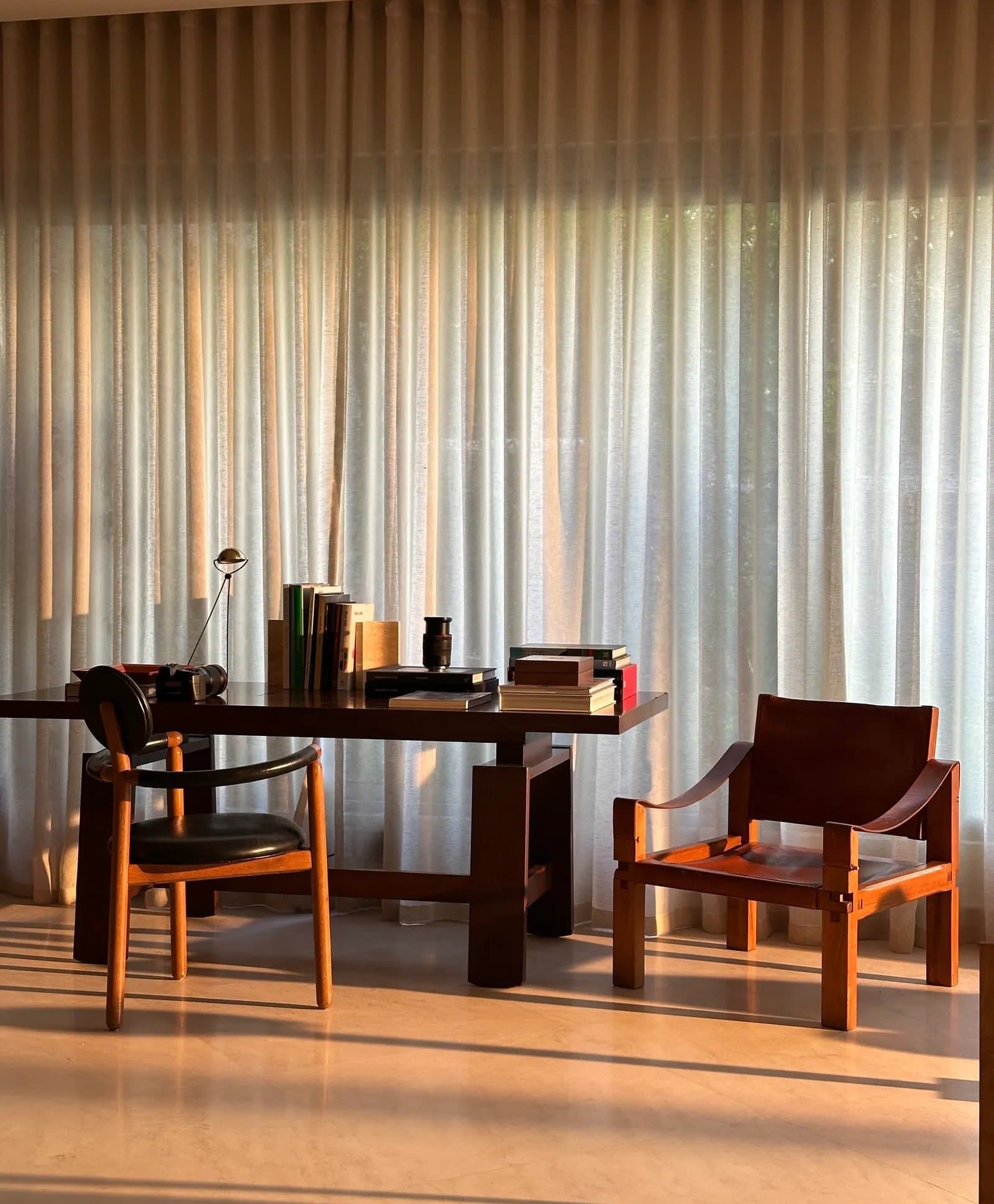 The study, arranged around a turned-leg desk and two distinct vintage chairs.