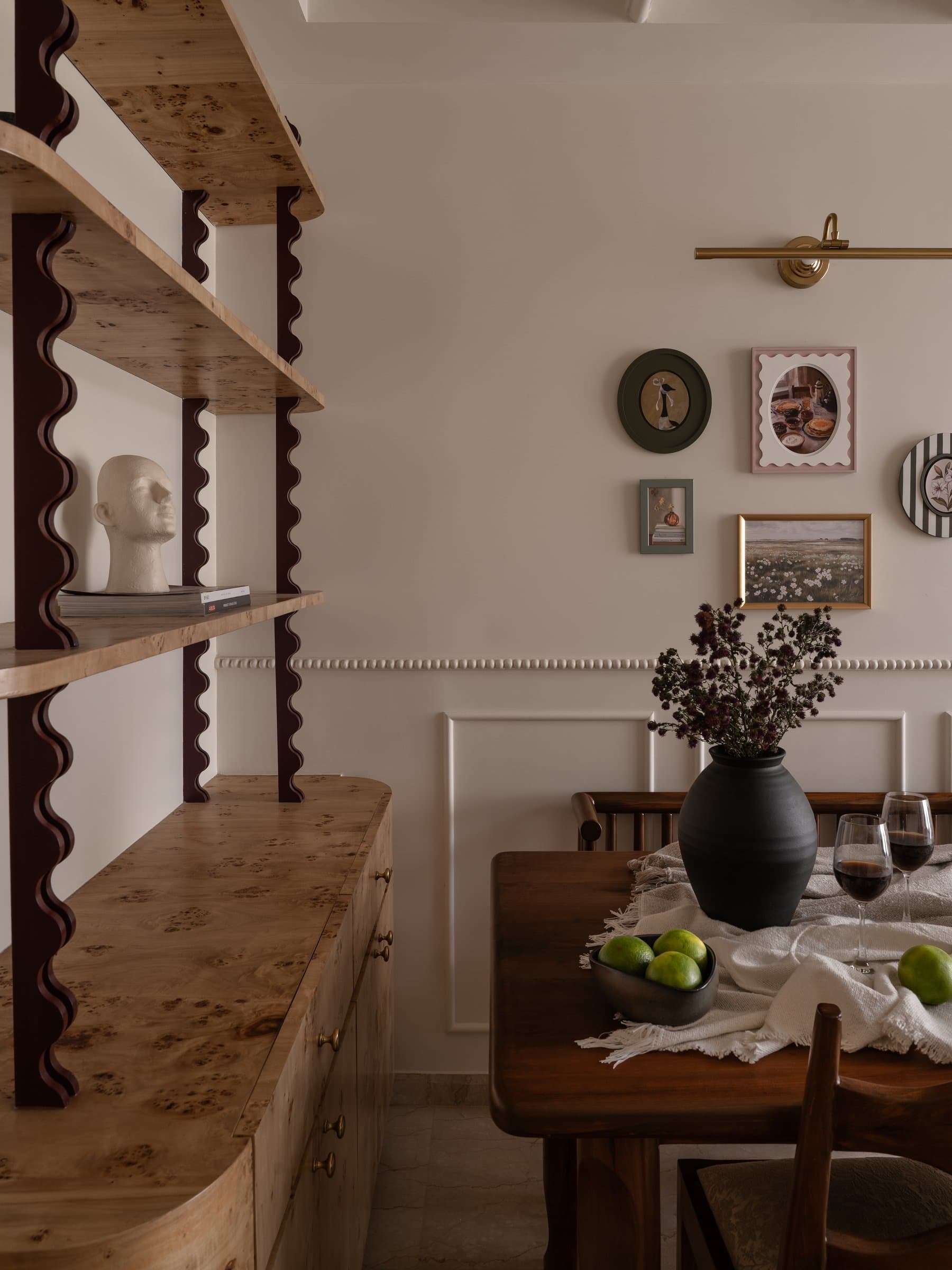 A closer view of the burl-wood shelving, its mottled grain held by dark scalloped vertical supports