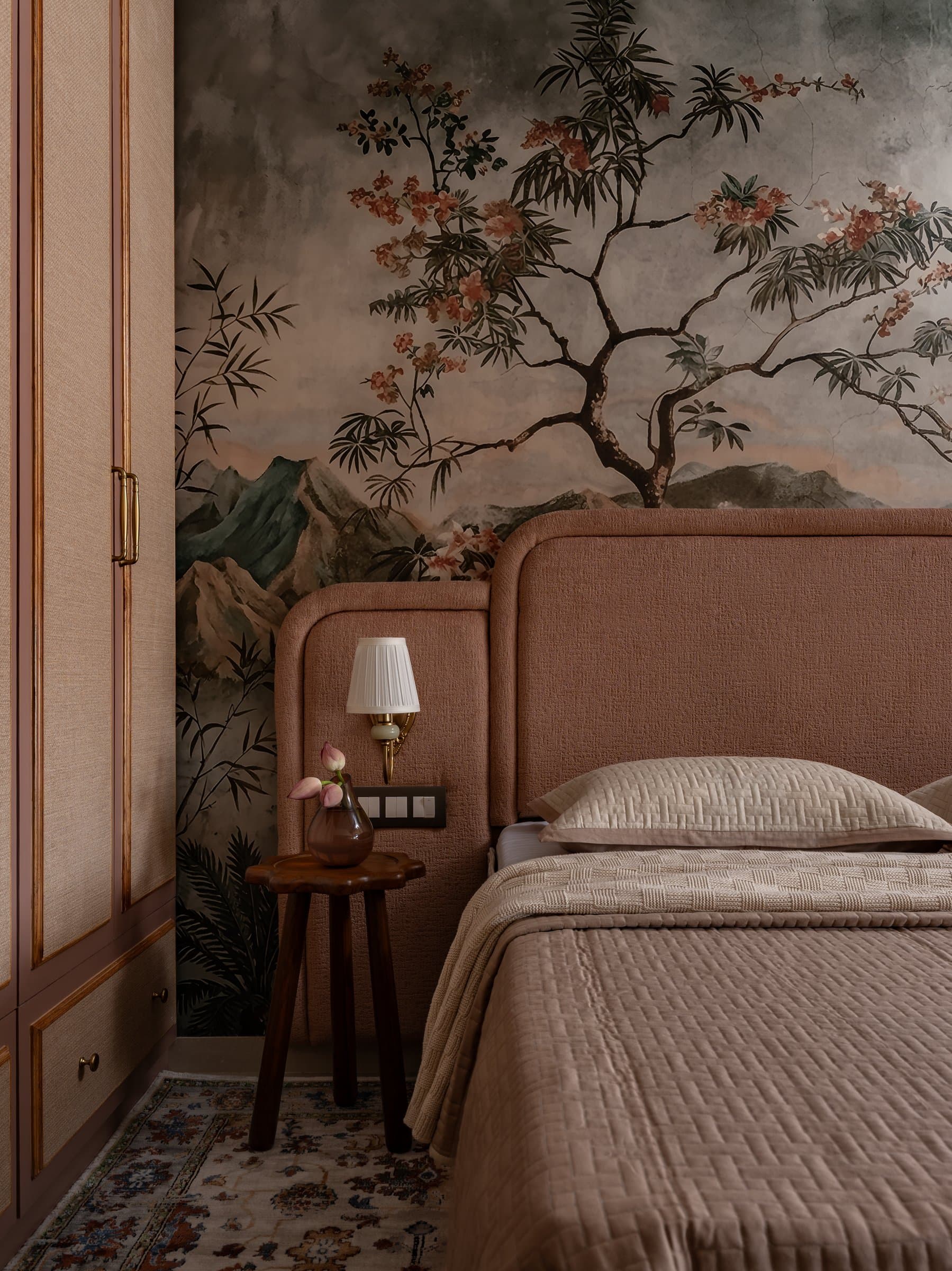 The second bedroom, where a hand-painted mural of a flowering tree lends the room the quality of a sun-faded fresco