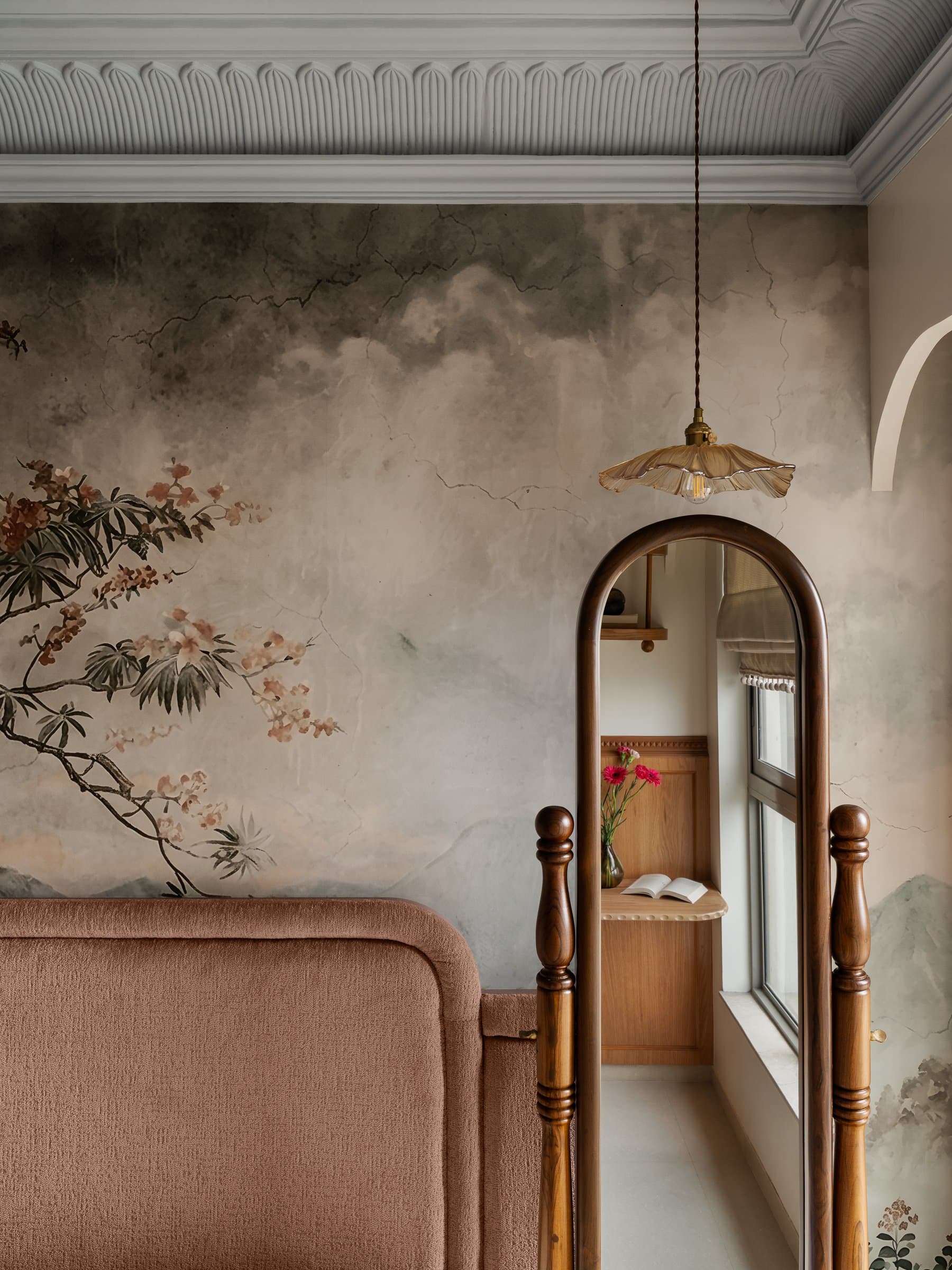 Where the hand-painted mural meets a scalloped plaster cornice and an arched mirror on turned posts
