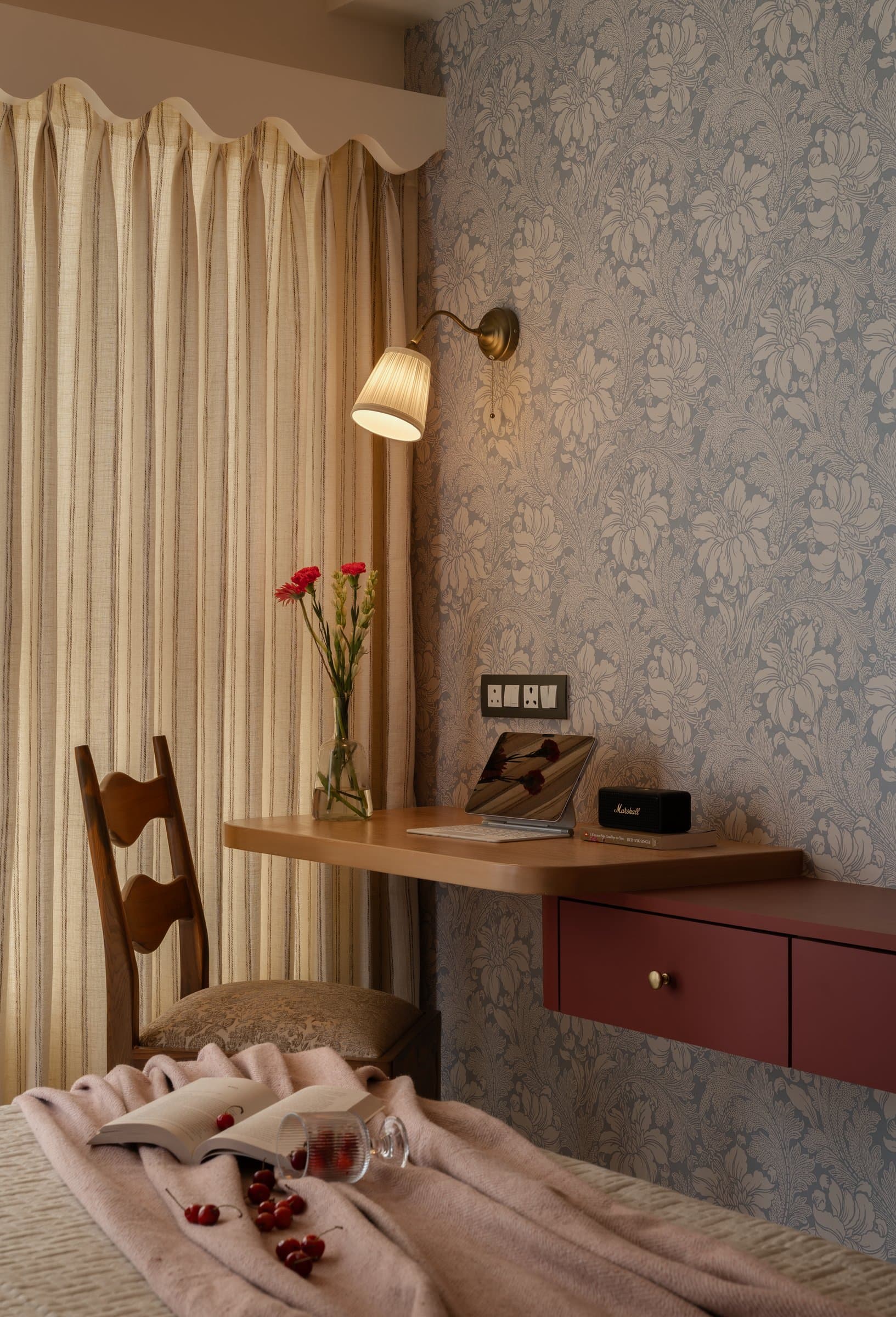 A second working alcove, where a floating desk in warm wood meets a suspended cabinet in the home's signature oxblood