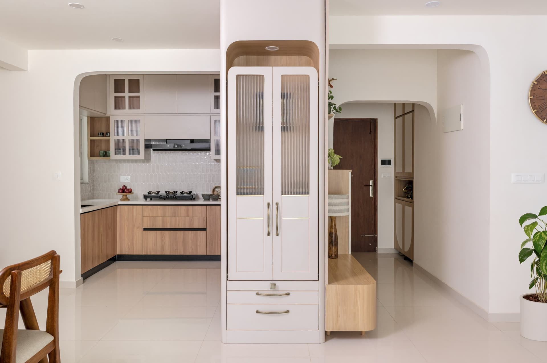 A slim joinery column marks the transition between the living-dining volume, the entry, and the kitchen