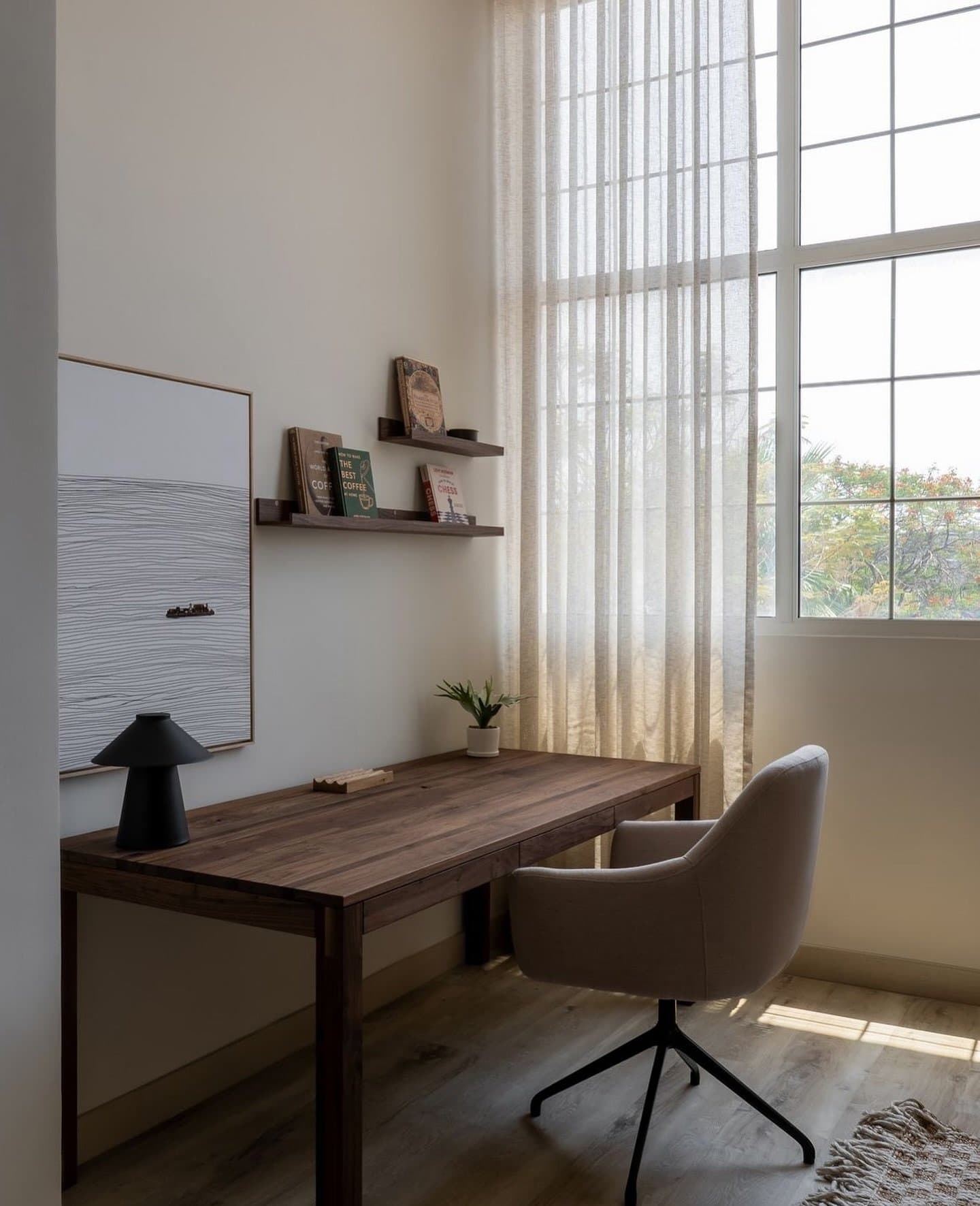 A compact study corner: solid wood desk, floating shelves and a pale swivel chair.