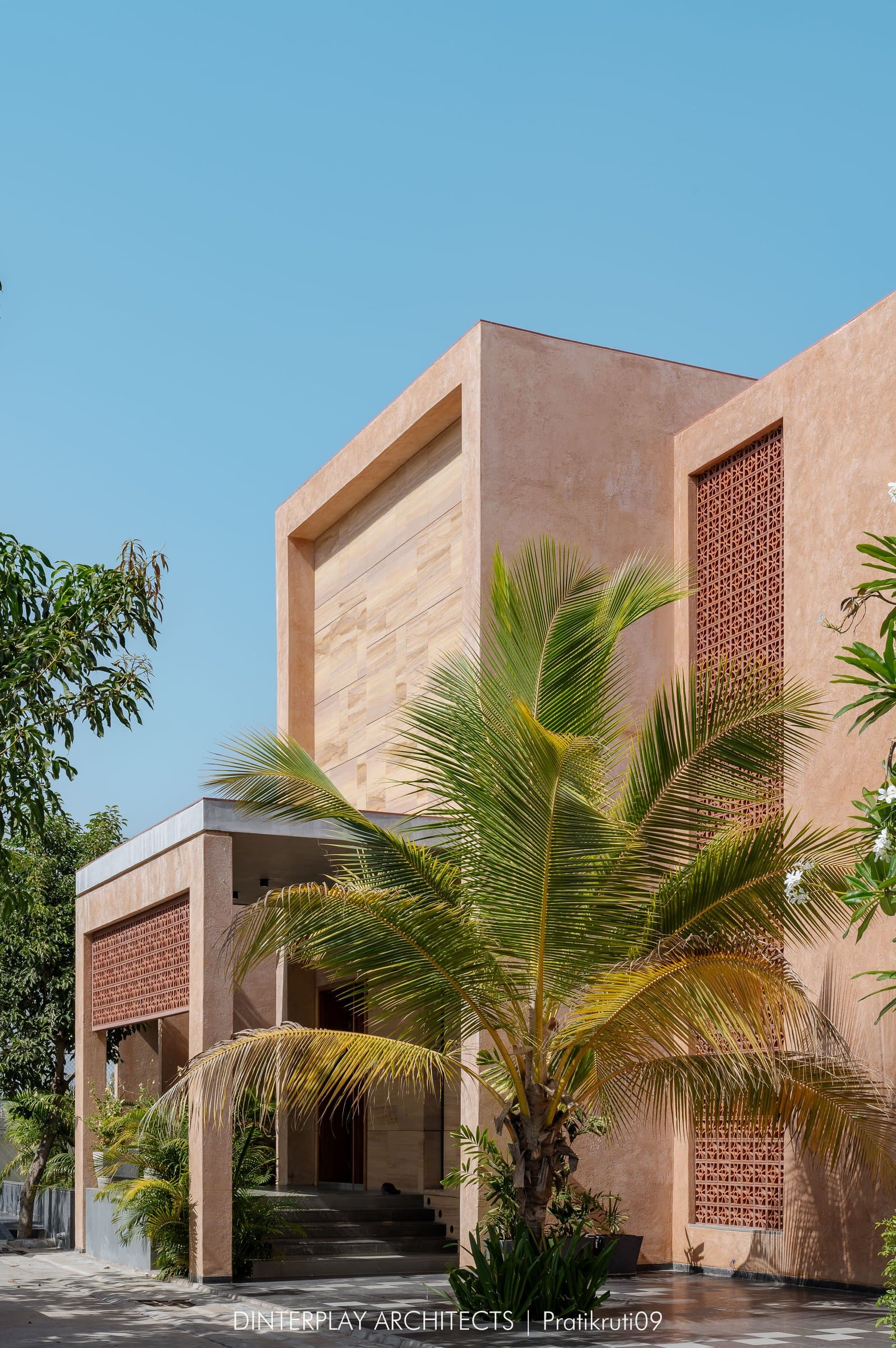 The plaster and sandstone facade, with jaali screens set flush into the upper mass