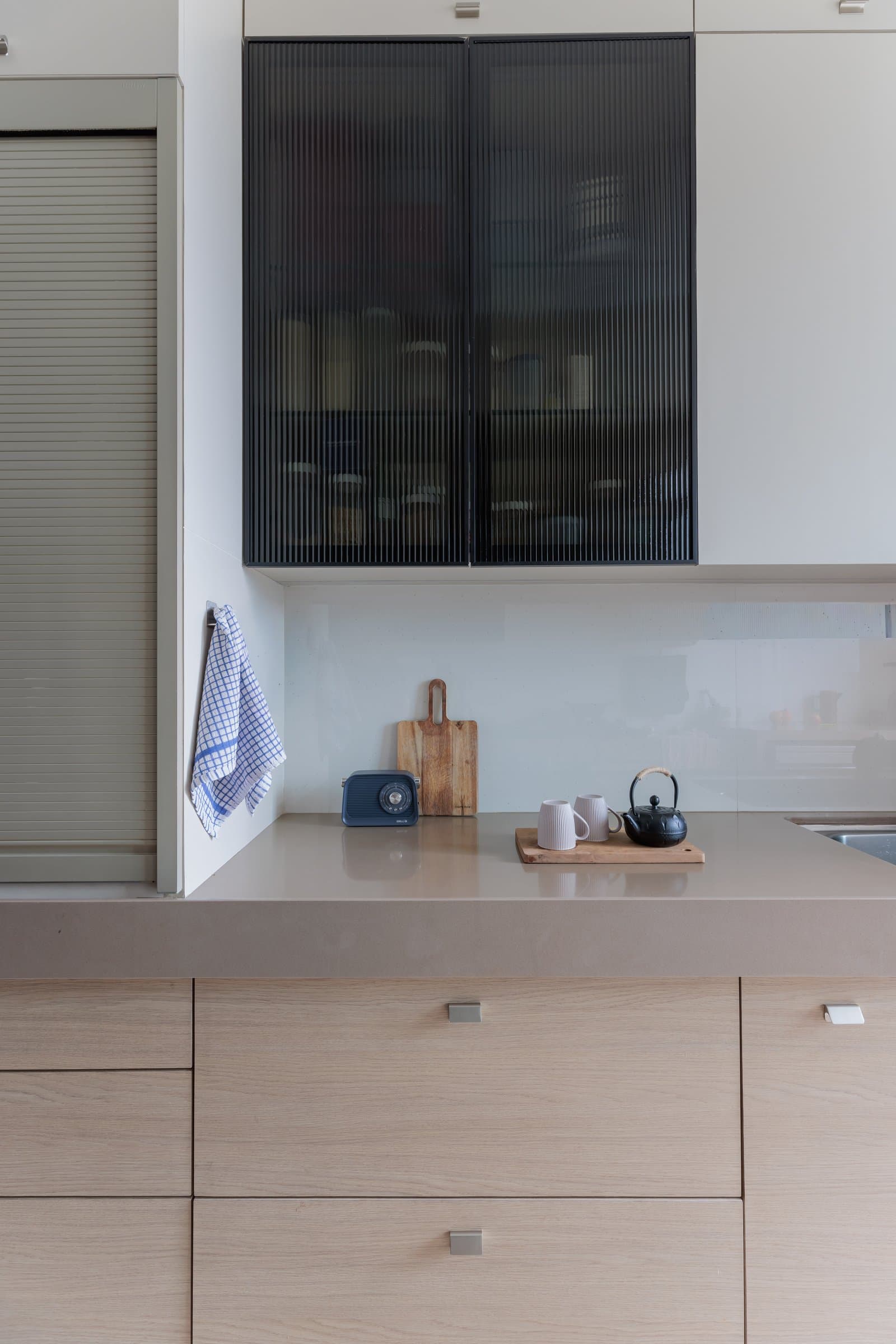 A closer view of the kitchen counter, where a vintage radio and small ceramics speak to daily use rather than display
