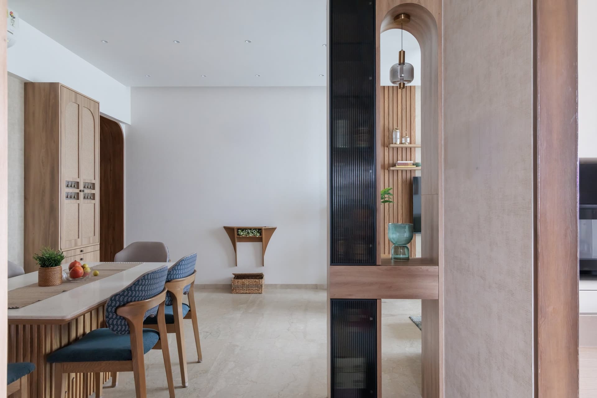 A reeded-glass and timber partition frames a display niche while concealing a bar cabinet on its reverse