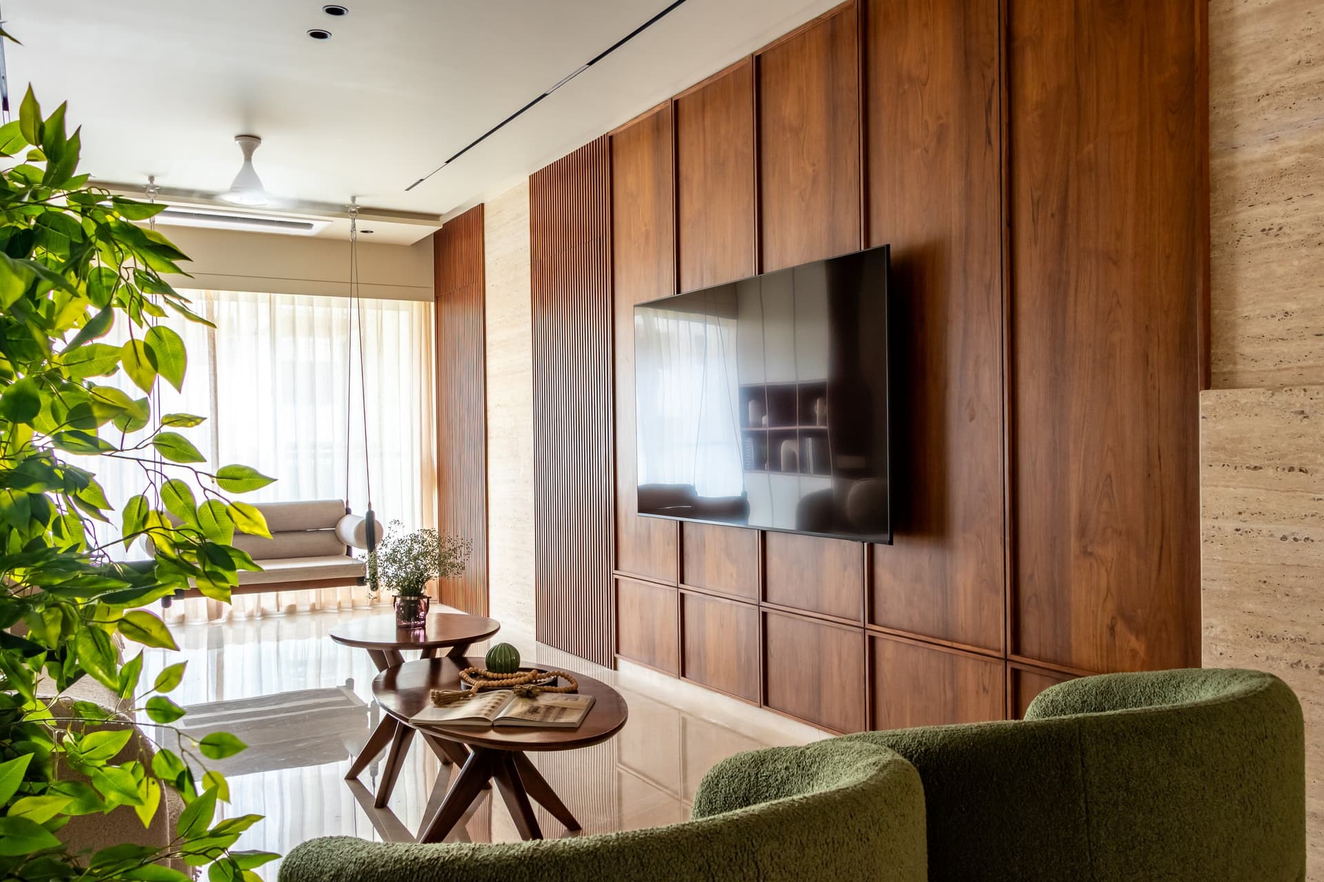 The media wall, absorbing the television into a rhythm of walnut-toned veneer, fluted inserts and a travertine return