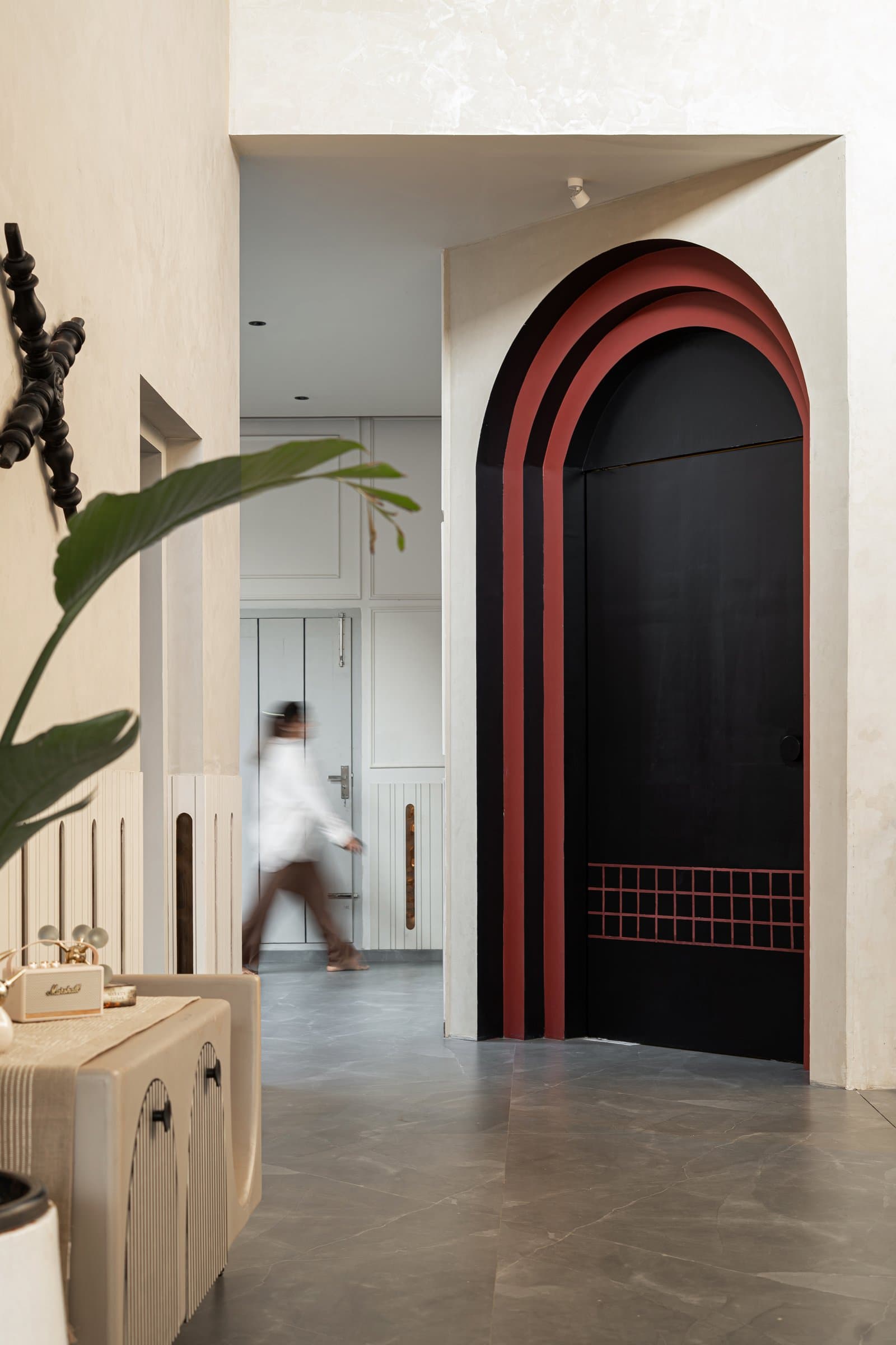 The home-theatre door, framed by concentric arches in a muted red