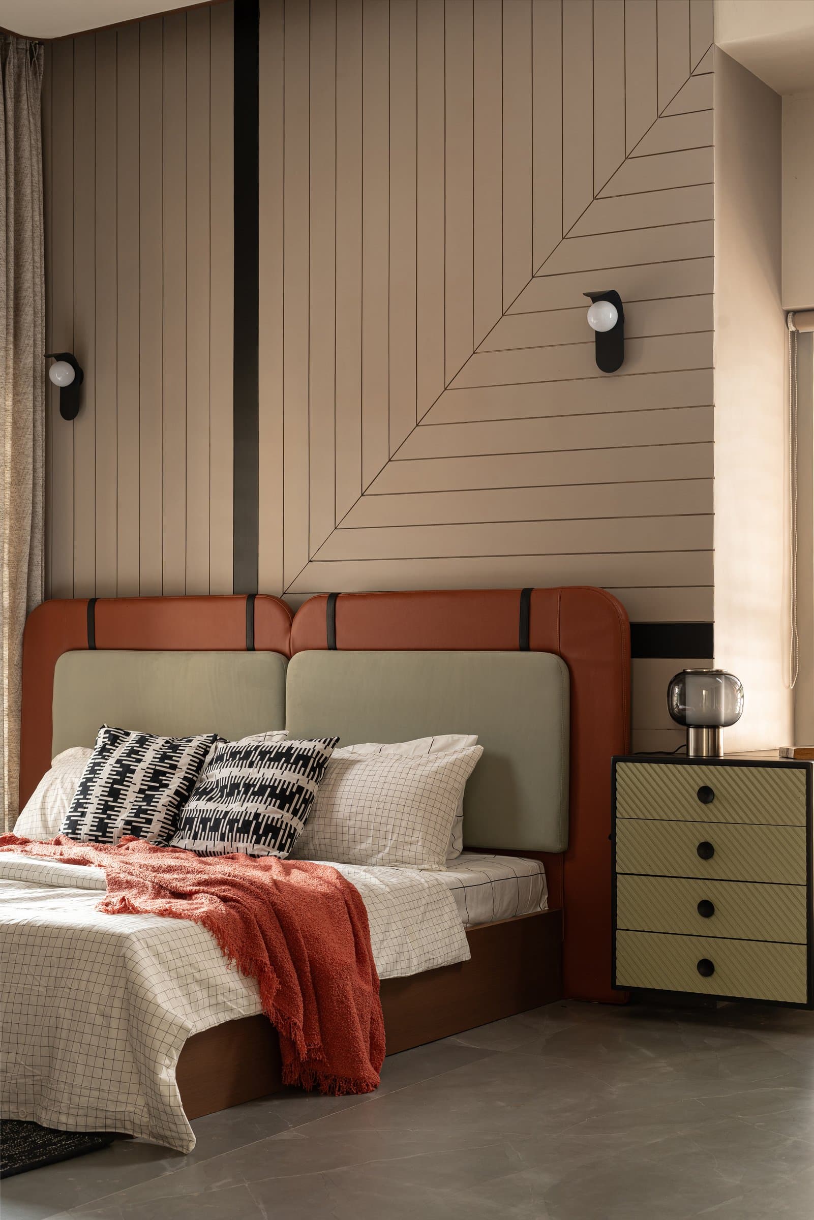 The second bedroom, where a grooved beige wall panel meets a terracotta-and-sage leather headboard