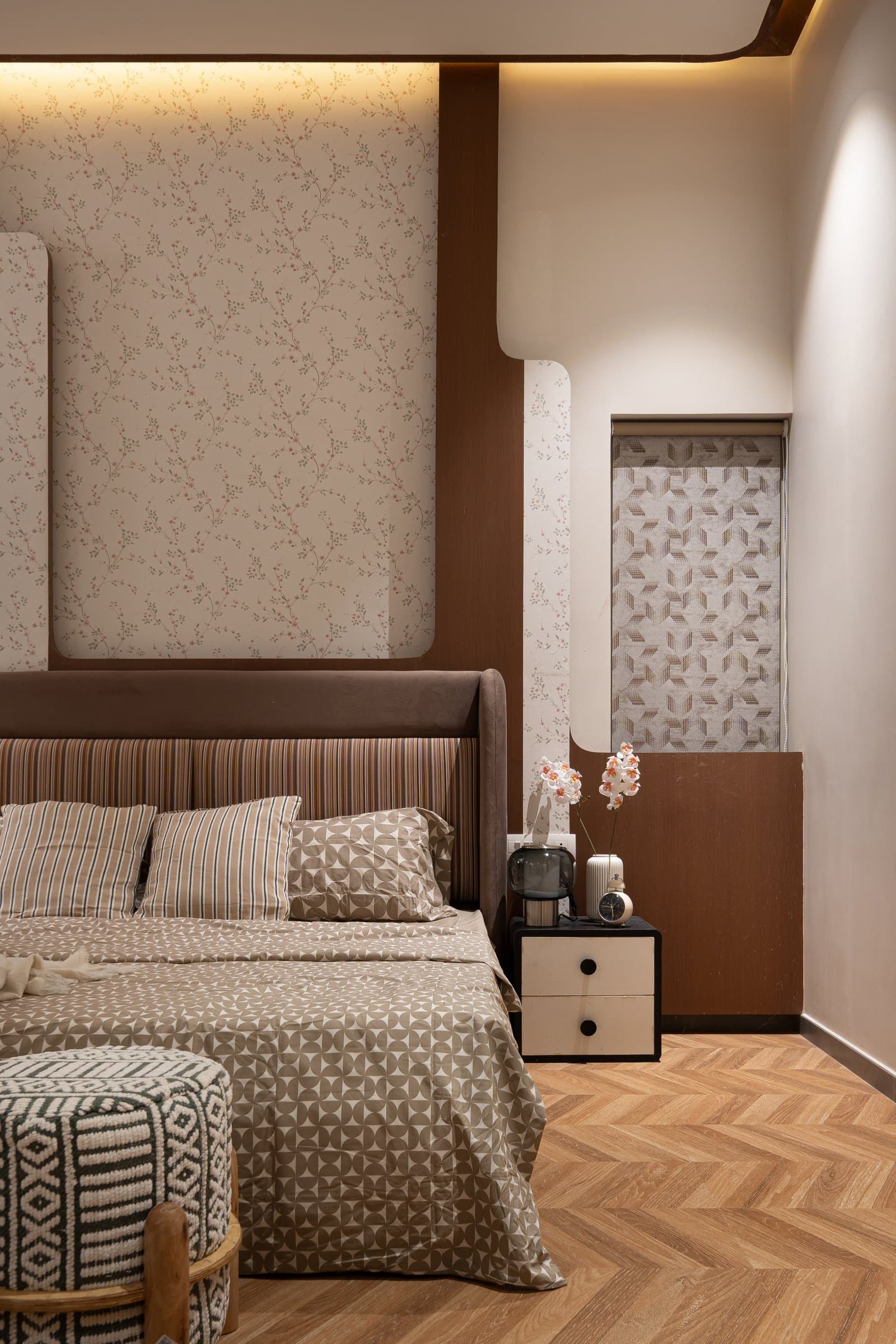 The third bedroom, where a patterned wallpaper sits behind a channel-tufted velvet headboard