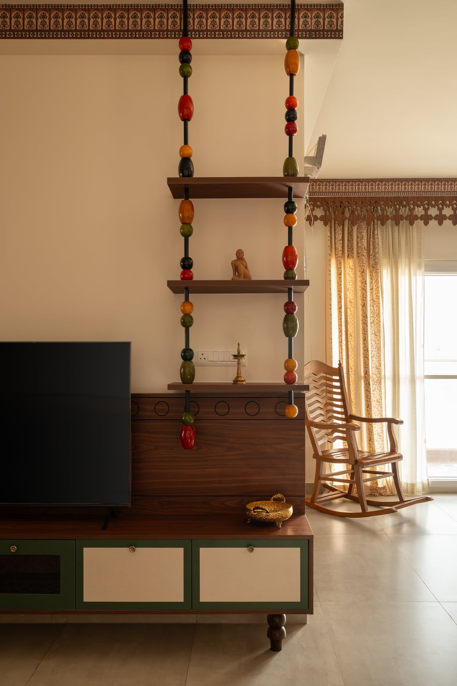 The Channapatna bead partition, lacquered in red, mustard, green and black, filters light between the living area and what lies beyond