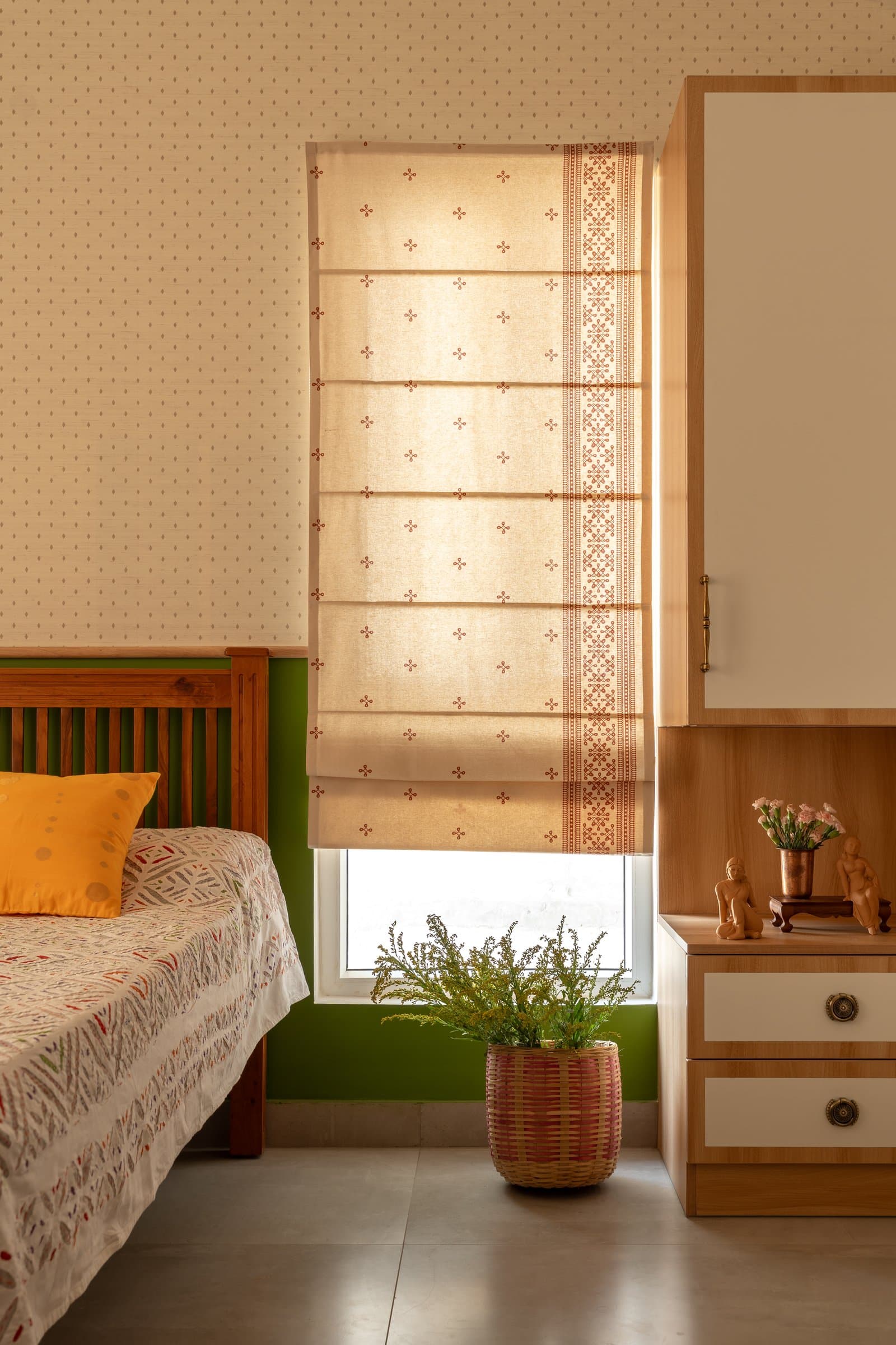 The guest bed against a mustard-green painted wall, its slatted wooden headboard echoing the living room's material language
