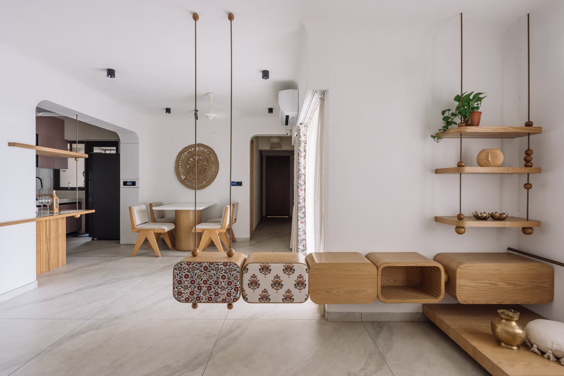The suspended composition seen from the dining side, where it acts as a visual threshold between the living area and the dining zone beyond